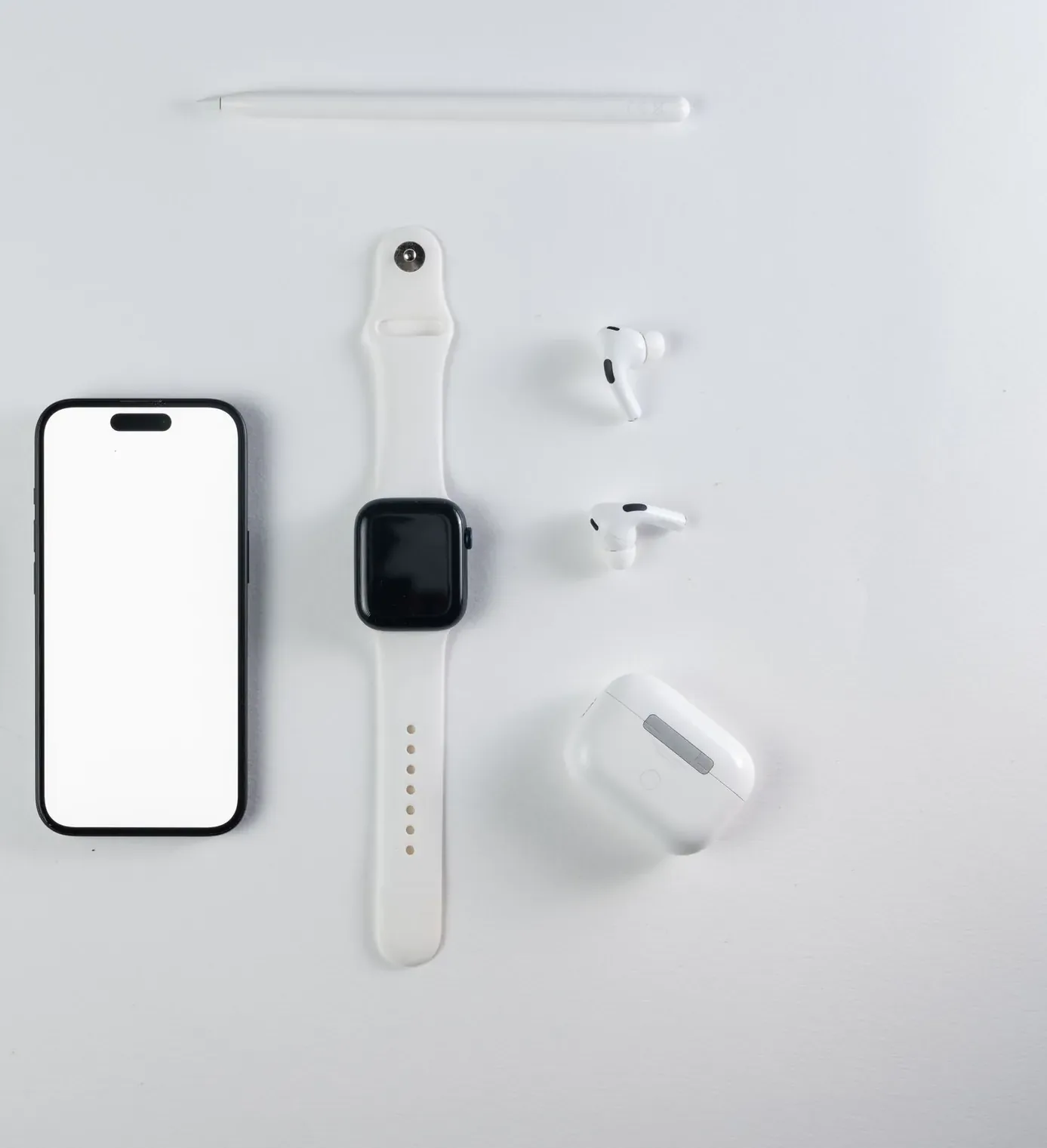 Celular, smartwatch, audífonos y mouse sobre fondo blanco